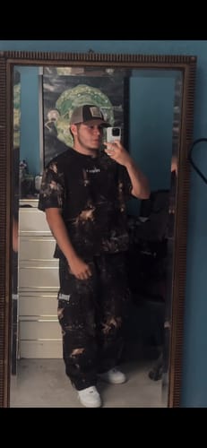 Customer in a mirror selfie wearing the baggy Heritage Camo Cargo Sweats.