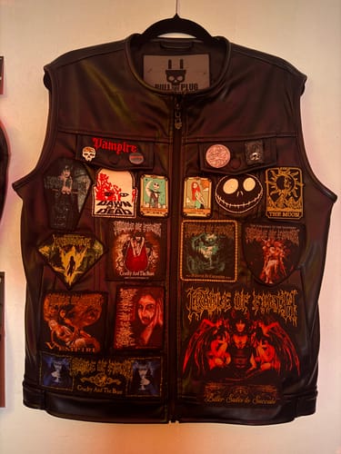 A customer's black leather battle vest, featuring the Cradle Of Filth - Dusk And Her Embrace patch on the bottom right among many others.