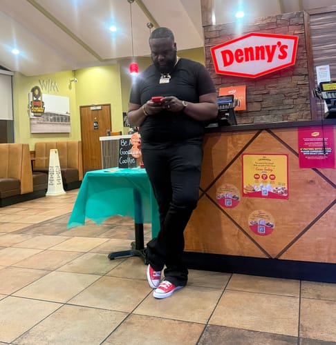 Reviewer standing indoors wearing the Vortex Stacked Denim in black, showing the stacked fit at the ankles.