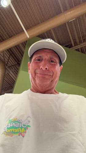 A low-angle photo of a reviewer wearing the white Disney "Don't Touch That Dial" vintage tee.
