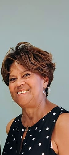 Reviewer smiling while wearing the short, wavy Vanessa Artisa Bluebell wig.