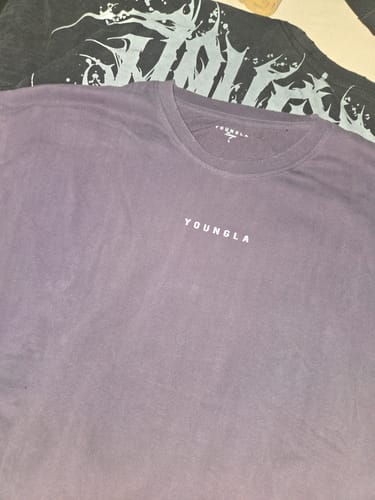 Customer's purple Chaos Tee laid out, showing the distressed crewneck collar and small front logo.