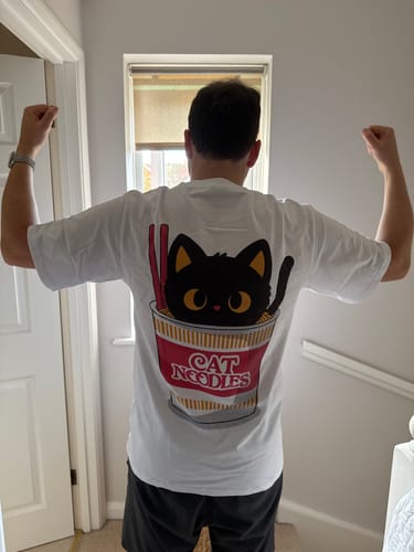 Reviewer from behind wearing the white Cat Noodles T-Shirt, showing the large back graphic.