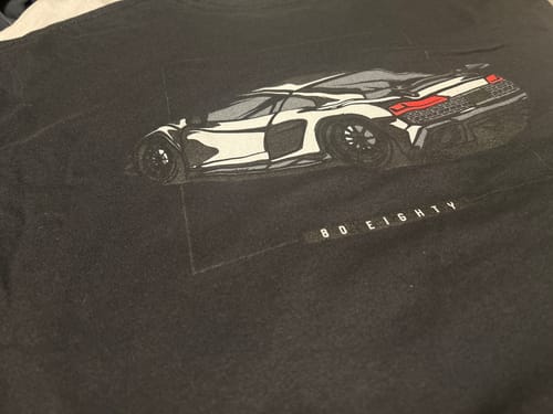 Reviewer's close-up of the black 80Eighty DCG89 Shirt showing the car graphic and brand name.