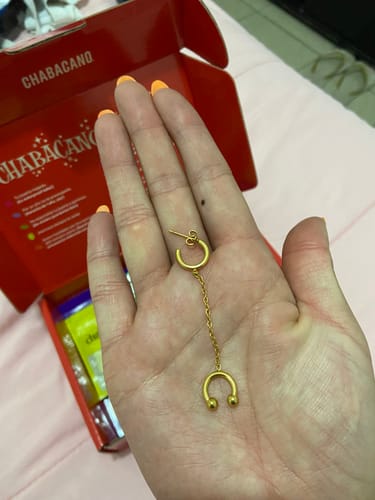 Cliente mostrando el Ear Cuff con extensión dorado en la palma de su mano.