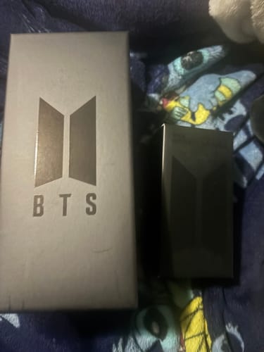 Customer's BTS Official Light Stick Ver.4 and Cradle shown in their black packaging boxes on a patterned blanket.