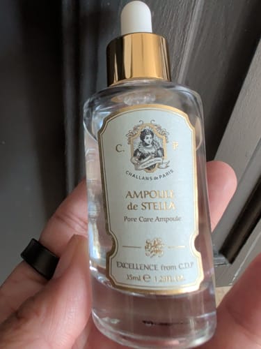 Customer holding the Ampoule de Stella pore care ampoule in its clear glass bottle.