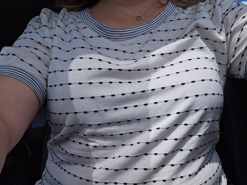A close-up of a customer wearing the Dashed Lines Striped Trim Tee, showing the fit and the detail of the pattern.