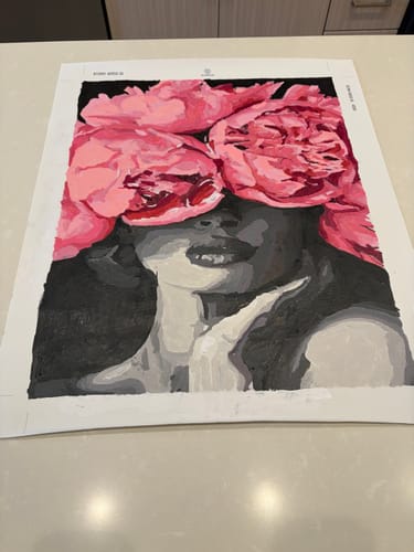 Customer's Noir Woman Paint by Numbers painting, showing a grayscale face with bright pink flowers over the eyes.