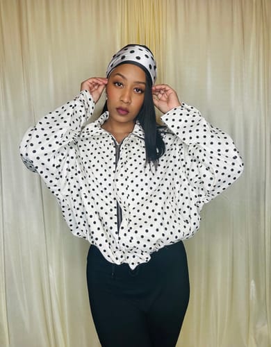 Reviewer wearing the jacket from the Gloria Polka Dot Co-Ord Set with black pants and a matching headband.