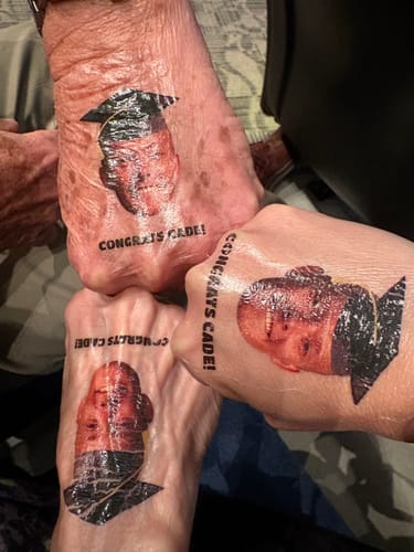 Reviewer and others show matching Graduation Hat tattoos on their hands and feet.