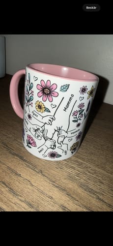 Kundens vita Kärleksmugg med rosa insida, som visar en personlig design med händer och ordet 'Mamma'.