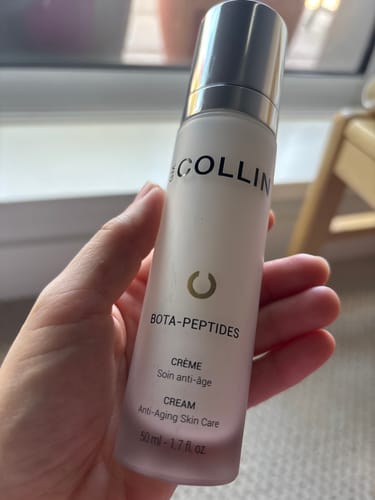 Customer holding a white bottle of G.M. Collin anti-aging cream.