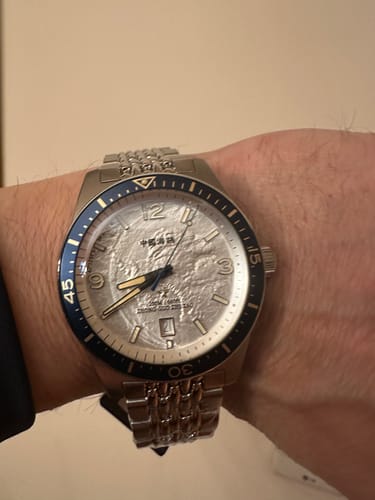 Customer wearing the Antarctic Expedition Dive Watch, showing its textured white dial and blue bezel on their wrist.