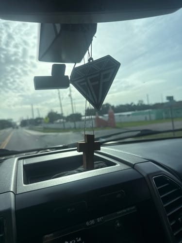 Customer's black, diamond-shaped GFP Air Freshener hanging from the rearview mirror of a car.