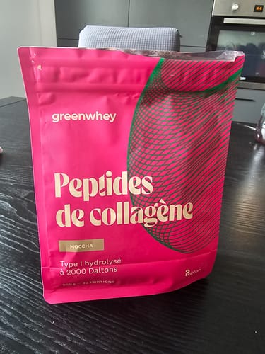 Sachet rose des Peptides de Collagène d'un client, saveur moccha, posé sur une table de cuisine.