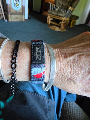 A close-up of a reviewer's wrist wearing the Angels Are Near Bracelet stacked with other bracelets.