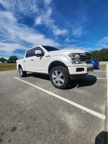 Customer's white Ford F150 showing a lifted stance after installing the suspension kit.