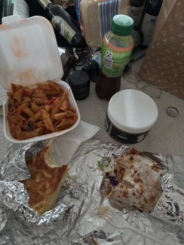 Die THC Space Cubes Dose eines Kunden auf einem unordentlichen Tisch mit Essen und Getränken.
