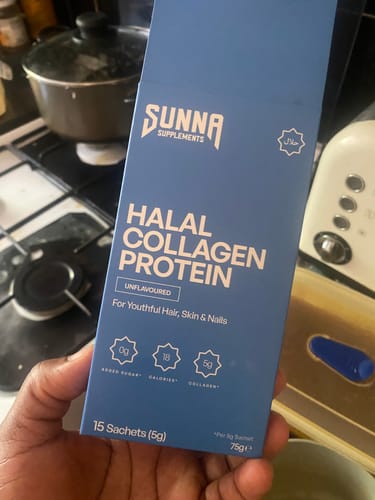 A customer holds the blue box of unflavoured Halal Collagen Protein Sachets in their kitchen.