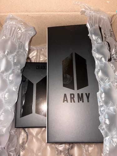 Customer's black packaging for the BTS OFFICIAL LIGHT STICK VER.4 + CRADLE inside a shipping box.
