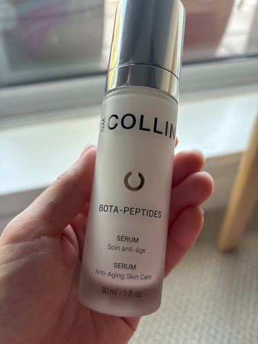 Reviewer holding the frosted bottle of GM Collin Bota-Peptides Serum.