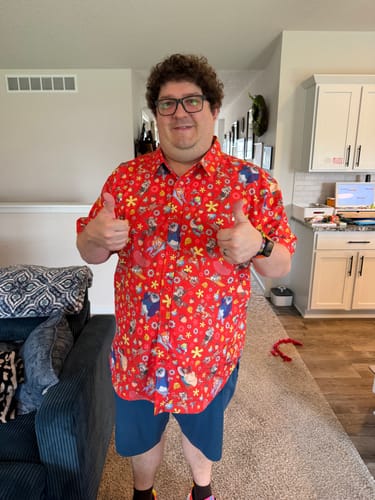 Reviewer gives two thumbs up while wearing the red Chip 'n Dale Rescue Rangers shirt indoors.