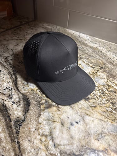 Customer's black 80Eighty® Limited Edition DCG89 Hat with an embroidered car outline, shown on a granite countertop.
