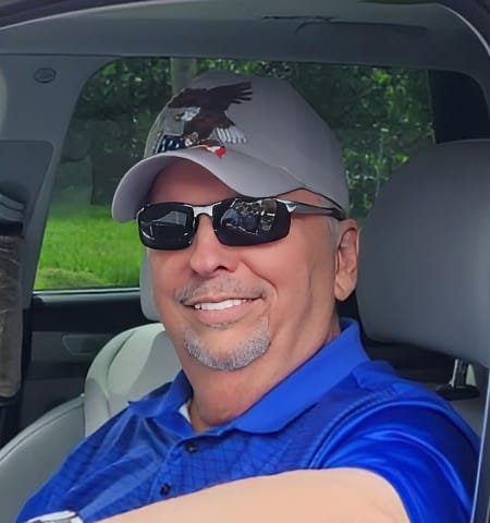 Reviewer in a car, showing off a bright, confident smile with their Spare Veneers.