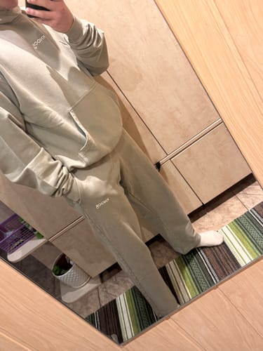 Reviewer in a mirror selfie wearing the dune-colored Straight Cut Joggers with a matching hoodie.