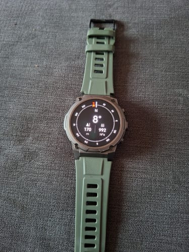 Customer's smartwatch with a green strap, showing the compass on the active watch face.
