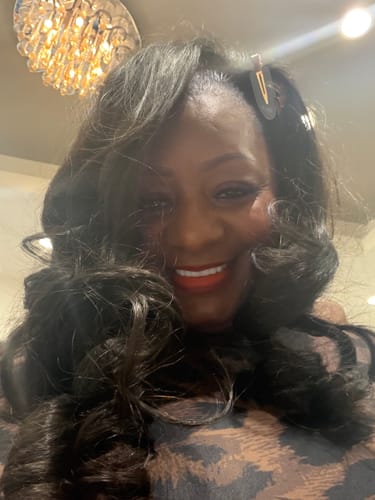 Close-up of a reviewer smiling while wearing the top of the Naked Print Bodysuit.