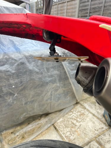 Reviewer's Rear Light fitted to the bracket under the tail of a red motorcycle.
