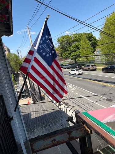 Customer's 1776 to 2026 Betsy Ross Flag with embroidered stars and numbers flying from a balcony.