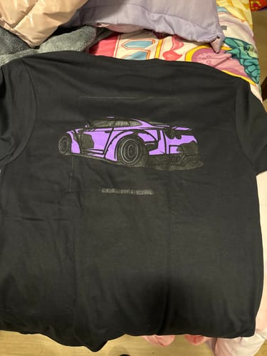 Reviewer's black 80Eighty® DCG88 Shirt laid flat, showing the purple car graphic on the back.
