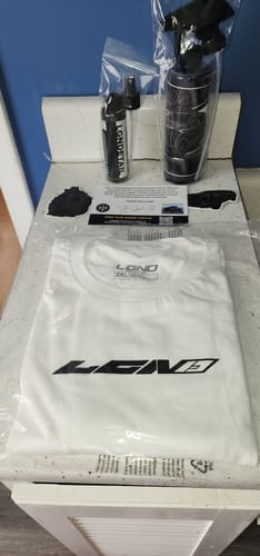Customer's items from the LGND92 Mystery CASH Box, including a t-shirt, two spray bottles, and decals.