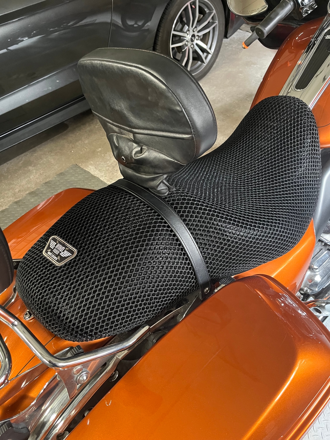 Harley Road Glide with 3D mesh seat cover installed parked at a motel lot, showing airflow gap between rider surface and base