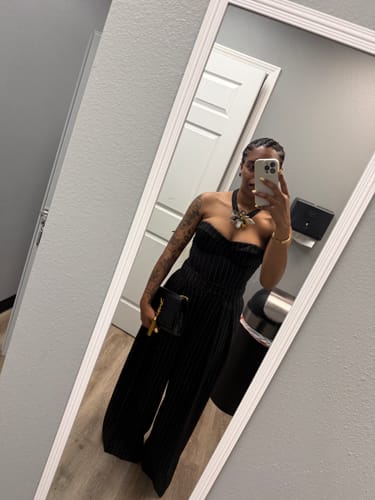Reviewer taking a mirror selfie wearing the black Suiting Pinstripe Bustier with matching pinstripe pants.