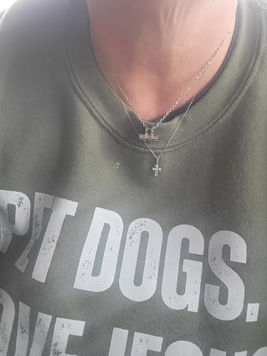 Customer wearing the Timeless Capsule Urn Pendant layered with another necklace against a green sweatshirt.