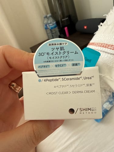 Customer holding the white and blue box of Shimbi Method Derma Cream in its original packaging.