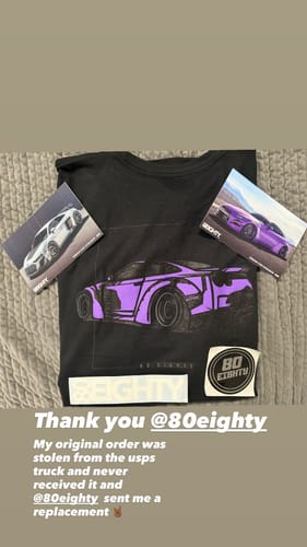 Customer's black 80Eighty DCG88 Shirt with a purple car graphic, laid flat with stickers and cards from the brand.