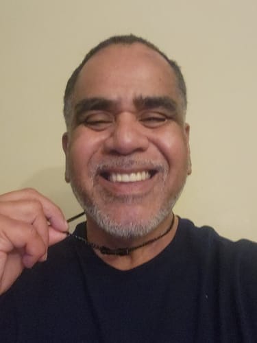 Reviewer smiling while showing off their personalized Legacy Necklace with black beads.