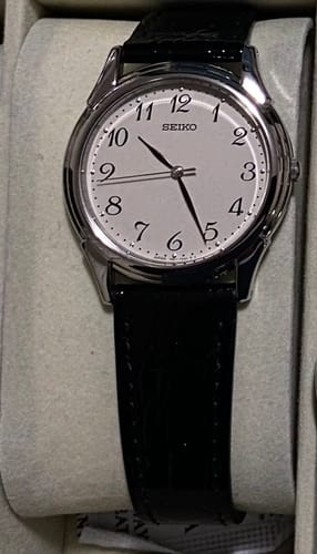 Reseñador muestra el reloj Seiko Selection SBTB005 con esfera blanca y correa de cuero negra, dentro de su caja.