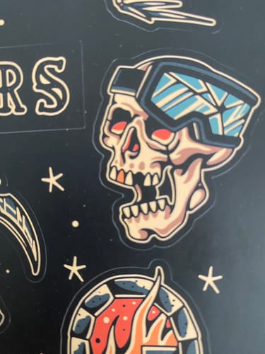 Reviewer's close-up of a sticker from the Lucky Dip Sticker Sheet, showing a skull wearing ski goggles.