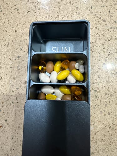 Customer showing the inside of their rugged metal pill case filled with vitamins.