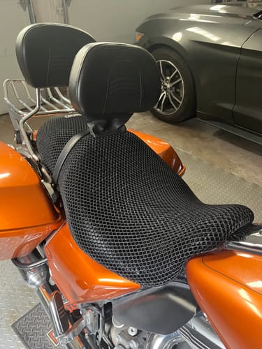 Customer's black mesh Wind Rider Seat Cover installed on an orange motorcycle in a garage.