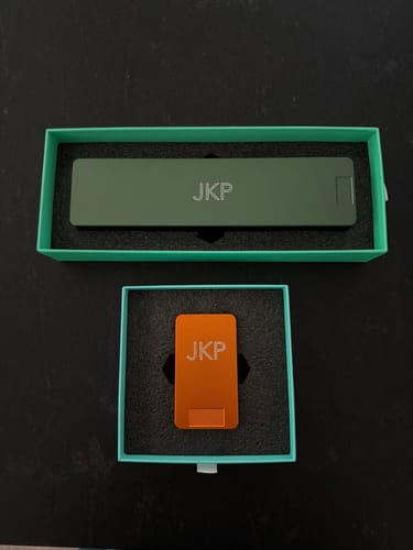Customer's long green pill case and smaller orange travel-sized pill case displayed in their original boxes.