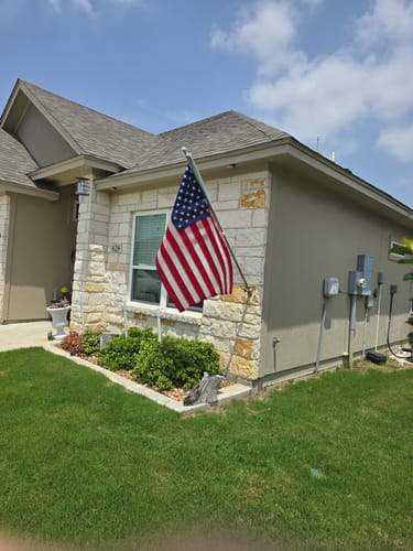 Customer's review image showing an American flag flying on a pole outside a home.