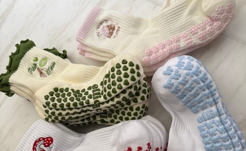 Customer's assortment of colorful Pilates & Matcha grip socks laid out on a floor.