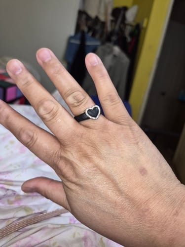 Reviewer's hand showing the black heart ring from the stackable set, worn without the side bands.